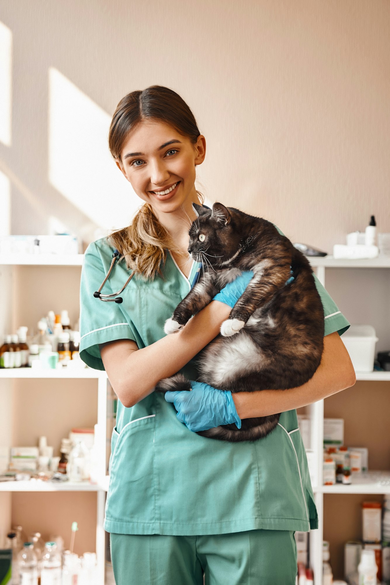 I love each of my patients Smiling female vet holding a big black fluffy cat in her hands, smiling